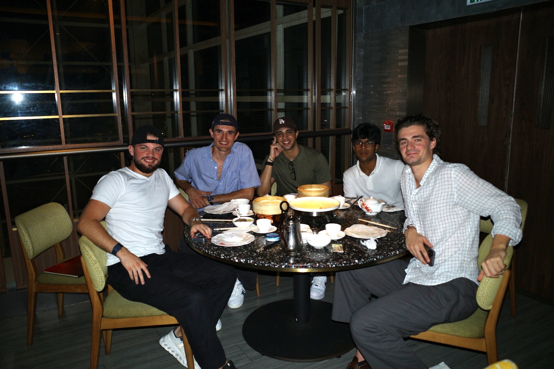 Five friends around a dinner table late at night
